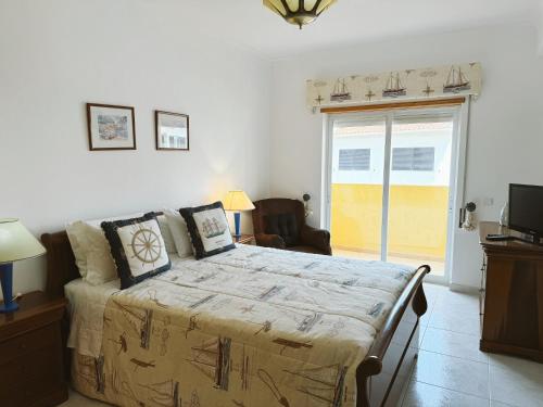 a bedroom with a large bed and a sliding glass door at Plaza Real - Silhueta Citadina in Portimão