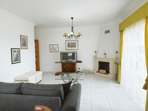 a living room with a couch and a tv at Plaza Real - Silhueta Citadina in Portimão