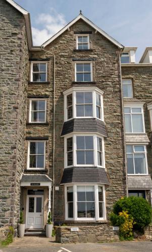 a large brick house with white windows at The Belmont Barmouth in Barmouth