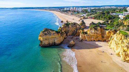 an aerial view of a beach with rocks in the ocean at Plaza Real - Silhueta Citadina in Portimão