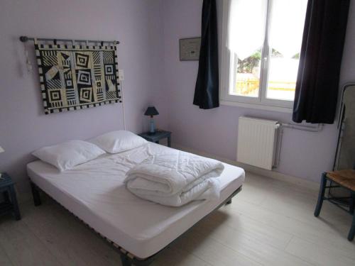 ein Schlafzimmer mit einem Bett mit weißen Laken und einem Fenster in der Unterkunft Maison 6 pers - 3ch à Saint Hilaire de riez classé 3 Etoiles in Saint-Hilaire-de-Riez