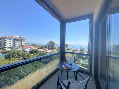 a balcony with a table and chairs and a view of the ocean at Ulu Panorama Residence in Alanya
