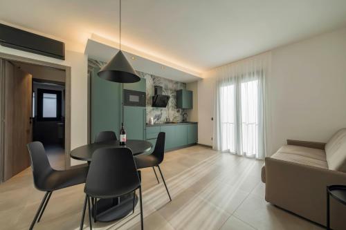 un soggiorno con tavolo, sedie e divano di ApartmentsGarda - Residenza Garda Deluxe a Garda