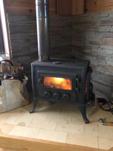 a black stove in a room with a brick wall at Takahira Base in Yakushima