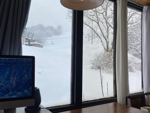 a computer monitor sitting on a desk in front of a window at ロッヂノエル in Seki