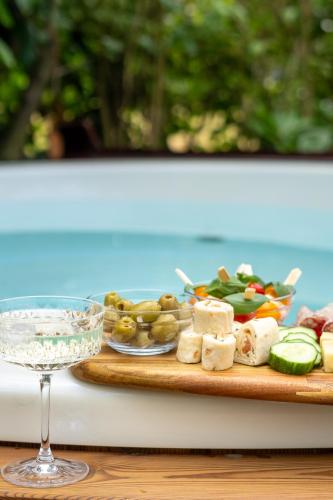 a table with a plate of food and a glass of wine at Hotel chique tiny wellness hottub & sauna in Voorthuizen