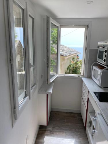 - une cuisine avec 2 fenêtres et un comptoir dans l'établissement A Macina, à Brando