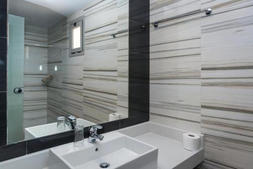 y baño con lavabo y espejo. en Porto Plazza Hotel, en Hersonissos