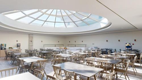 an empty classroom with tables and chairs and a skylight at The Dome Luxury in Limenaria