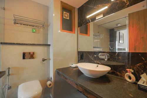 a bathroom with a sink and a toilet and a mirror at The Sanawar Heights I Kasauli I New Property in Kasauli