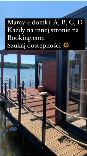 a wooden dock with a house on the water at "B" Domki na wodzie Barczewko 2 z 4 domków in Barczewko