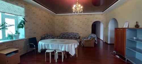 Una habitación con una mesa con sillas y una lámpara de araña. en Americana, en Zaozërnyy
