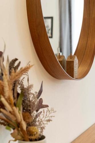 a mirror on a wall with a vase with a plant at Apartmány Marienhof in Znojmo