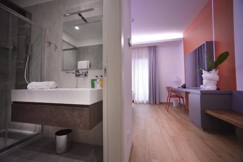 a bathroom with a sink and a shower and a desk at Santantonioresort in Riposto