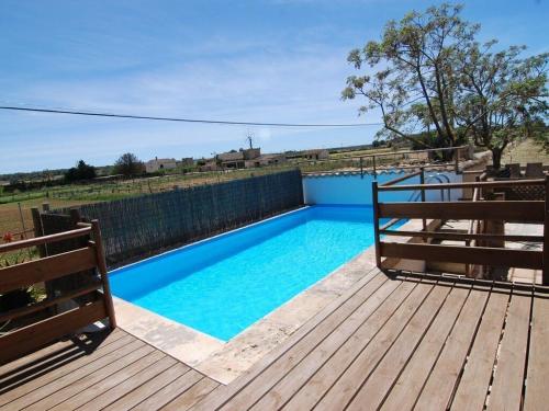 a blue swimming pool on a wooden deck at Bonita casa de campo típica Mallorquina in Sant Jordi