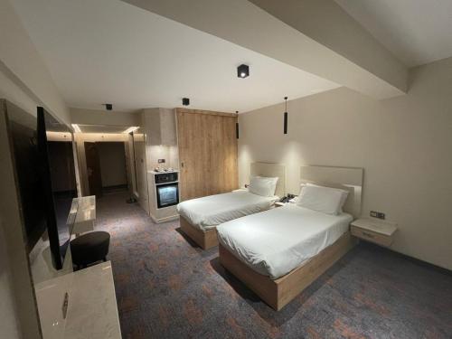 a hotel room with two beds and a television at Zamzam Hotel 1 in An Najaf