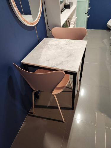 a marble table and two chairs in a room at Shinchon Y Hotel in Seoul