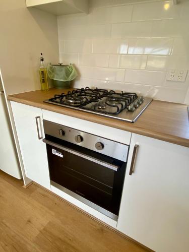 a stove top oven in a white kitchen at Berridale Alpine Retreat in Berridale
