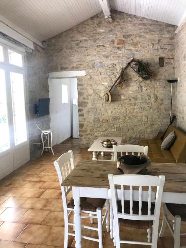 une salle à manger avec une table et des chaises en bois dans l'établissement gite la bergerie en bord d'Aveyron, à Saint-Antonin