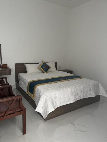 a bed in a white room with a bed sidx sidx sidx at Nhà nghỉ Pha Lê in Cao Lãnh