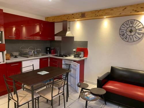 una cucina con un tavolo e un orologio a parete di La Roteirolle a Réotier