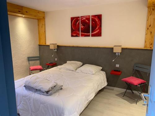 una camera da letto con un letto bianco e un dipinto rosso sul muro di La Roteirolle a Réotier