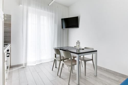 a dining room with a table and chairs and a television at Residence Diffuso Arcobaleno in Gabicce Mare