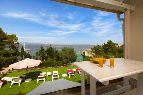 a table with chairs and a view of the water at Villa Baronnos in Gaios