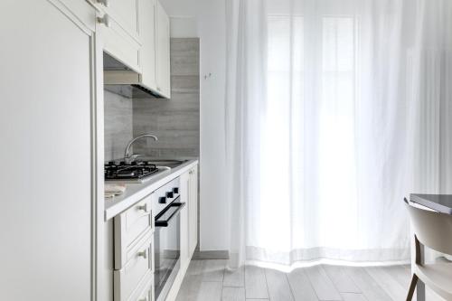 a kitchen with white cabinets and a sink and a window at Residence Diffuso Arcobaleno in Gabicce Mare