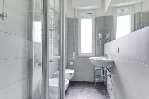 a white bathroom with a sink and a toilet at Residence Diffuso Arcobaleno in Gabicce Mare