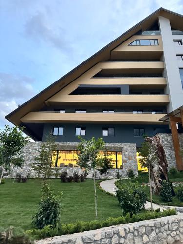 a large building with a lawn in front of it at Valbona Resort & Spa in Valbonë