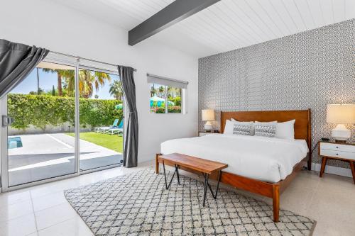 a bedroom with a bed and a sliding glass door at Alexander on Bedford in Palm Springs