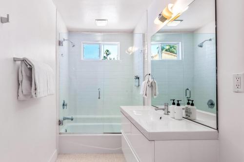 ein weißes Bad mit einem Waschbecken und einer Dusche in der Unterkunft Alexander on Bedford in Palm Springs
