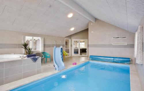 a large swimming pool with a water slide in a house at Gorgeous Home In Bogense With Sauna in Bogense