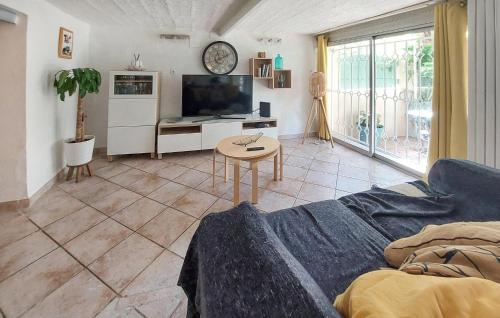 un salon avec un canapé, une télévision et une table dans l'établissement 1 Bedroom Cozy Apartment In Toulon, à Toulon