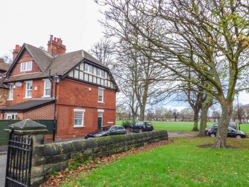 a large brick house with cars parked in front of it at House on the Green Spacious-Super location in Derby
