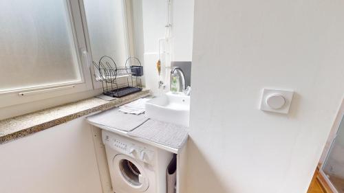 une salle de bain avec un lavabo et une machine à laver dans l'établissement Magda & Lena Strasbourg city center Bail Mobilité, à Strasbourg