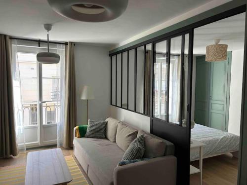 un salon avec un canapé et un lit dans l'établissement Au coeur du centre ville, à Dieppe