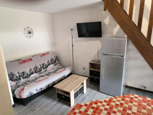 Cette petite chambre comprend un lit et une télévision. dans l'établissement Pavillon avec piscine place de pkg privée, à Argelès-sur-Mer