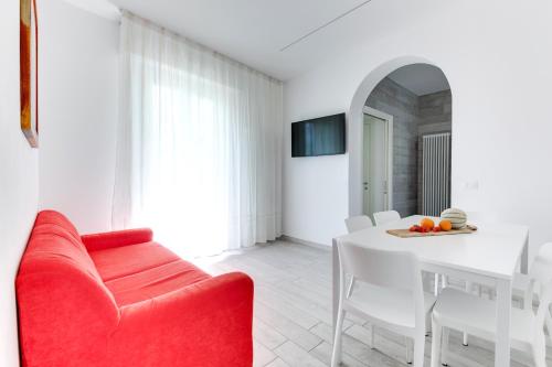 a living room with a red couch and a white table at Residence Diffuso Arcobaleno in Gabicce Mare