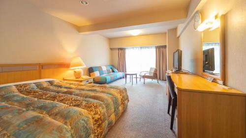 塩江町にあるハイパーリゾートヴィラ塩江のベッドとデスクが備わるホテルルームです。