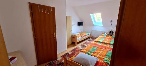 a small bedroom with two beds and a door at Ubytování v soukromí Olomučany in Olomučany