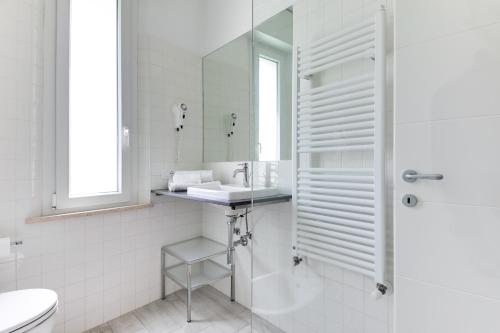 a white bathroom with a sink and a mirror at Residence Diffuso Arcobaleno in Gabicce Mare