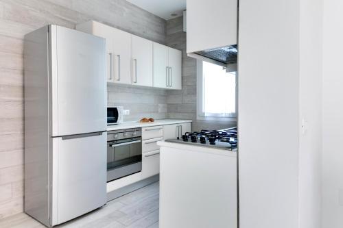 a kitchen with white appliances and white cabinets at Residence Diffuso Arcobaleno in Gabicce Mare