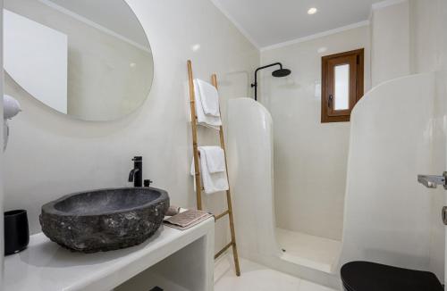 a bathroom with a stone sink and a shower at Leon Luxury Suites in Imerovigli