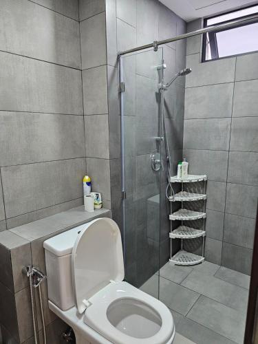 a bathroom with a toilet and a glass shower at K Avenue Kota Kinabalu in Donggongon
