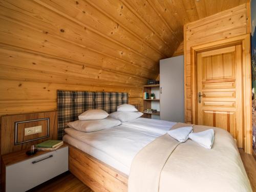 a bedroom with a bed in a wooden room at Domki "Na Dziedzinie" z Gorącą Balią in Szaflary