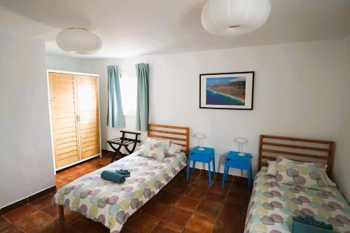 a bedroom with two beds and two blue tables at Timfay in Corralejo