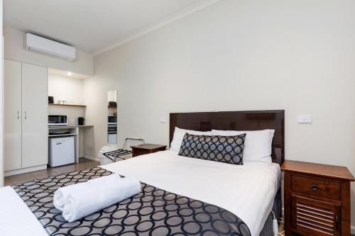 蒂默特Amaroo Motel Tumuts Best Accommodation的一间带大床的卧室和一间厨房