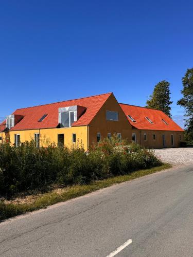 a house with red roofs on the side of a road at Amazing holiday apartment - Clara in Ebeltoft